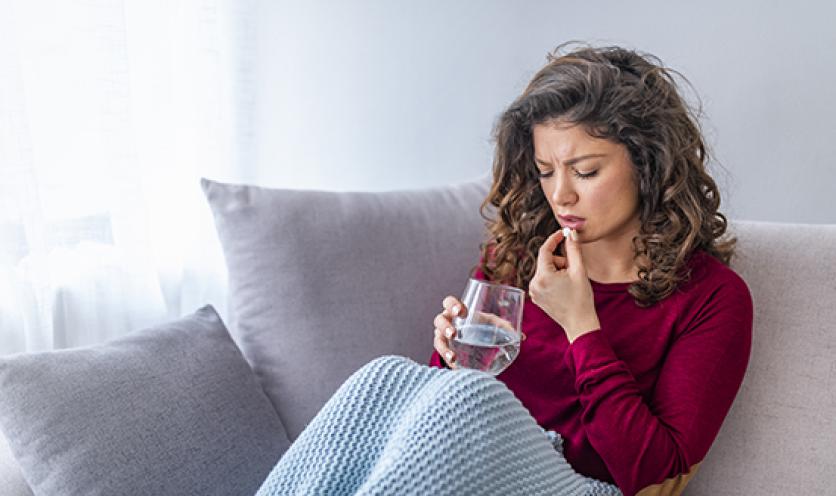 Woman Taking Meds on Couch