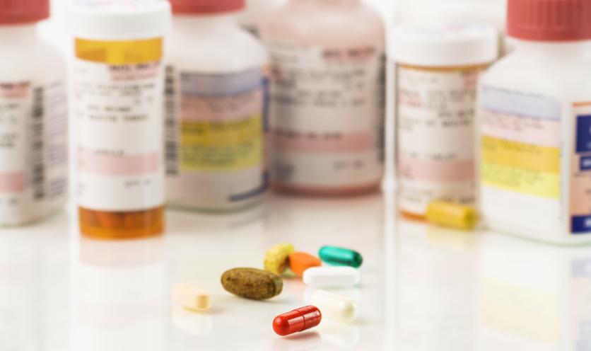 Woman Examined Pill Bottle while Smoking Cigarette